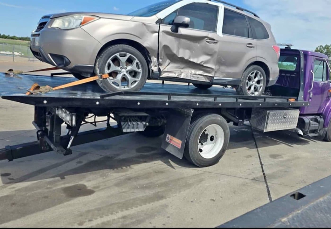 Camioneta con daño lateral asegurada sobre la plataforma de una grúa