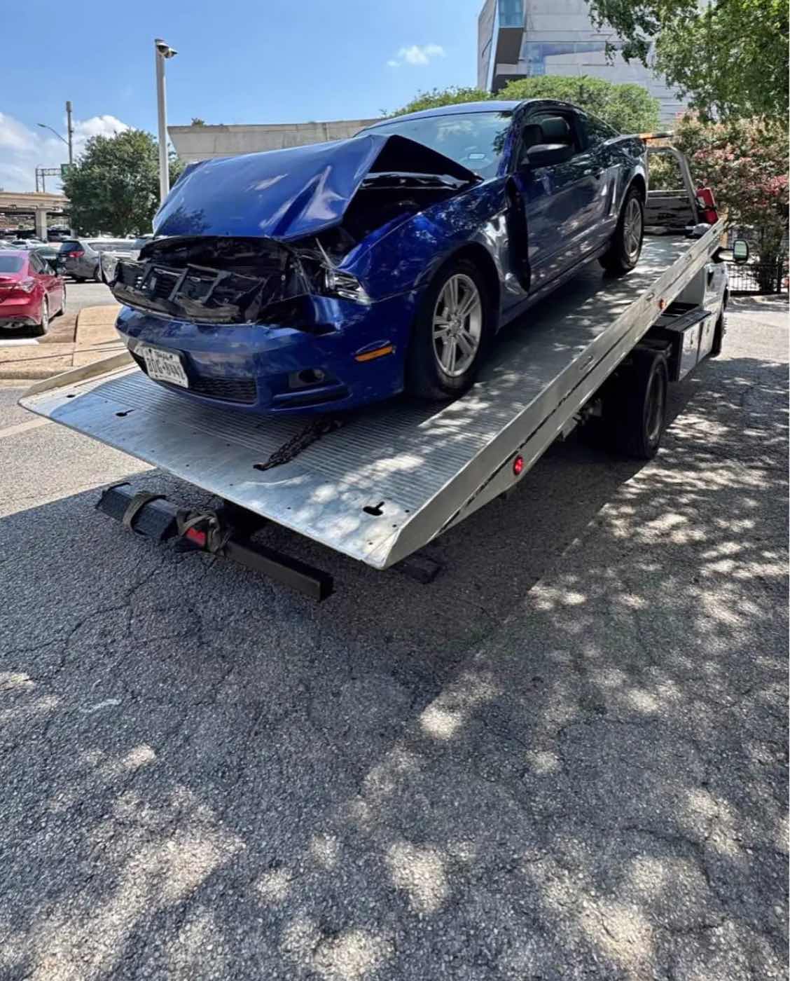 Auto deportivo chocado de frente, ya cargado en la plataforma